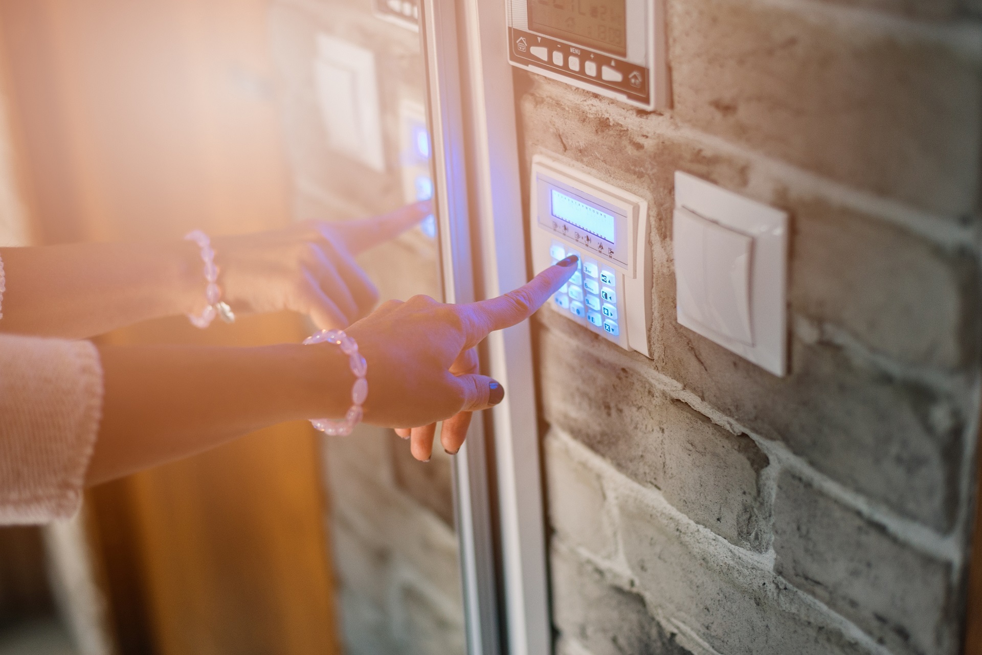 Woman entering alarm code on panel